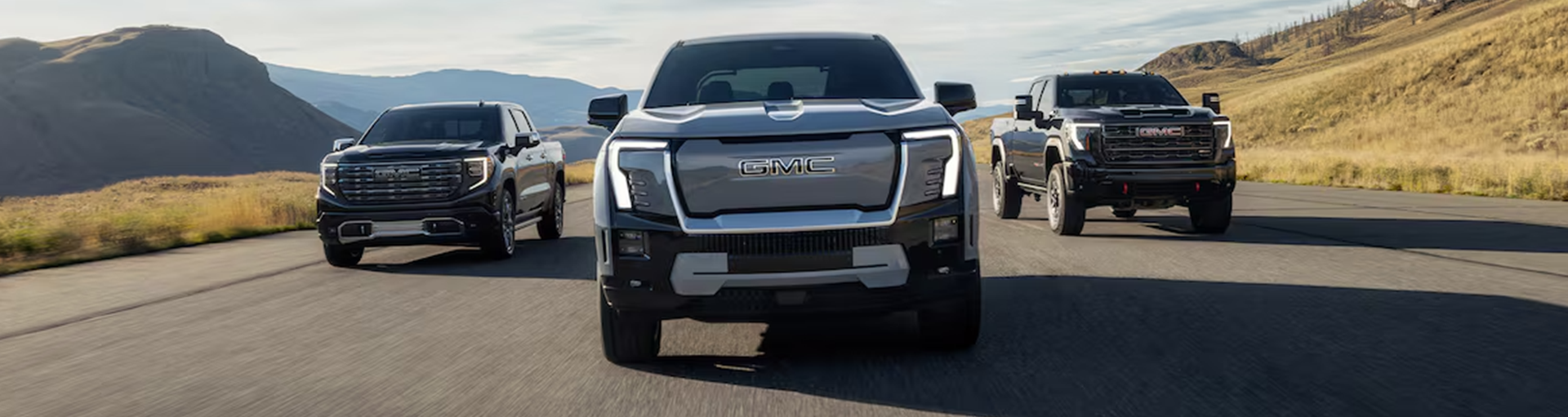 Three GMC Sierra 2500 HD trucks driving towards the camera.