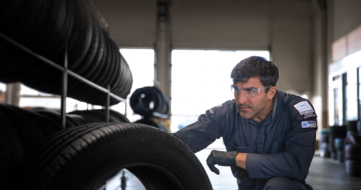 A service technician selecting tires for a car in the service center