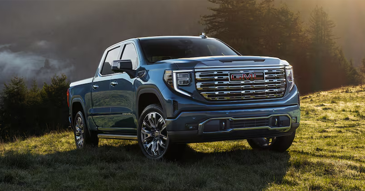A blue GMC Sierra 1500 pickup truck parked in an open field.