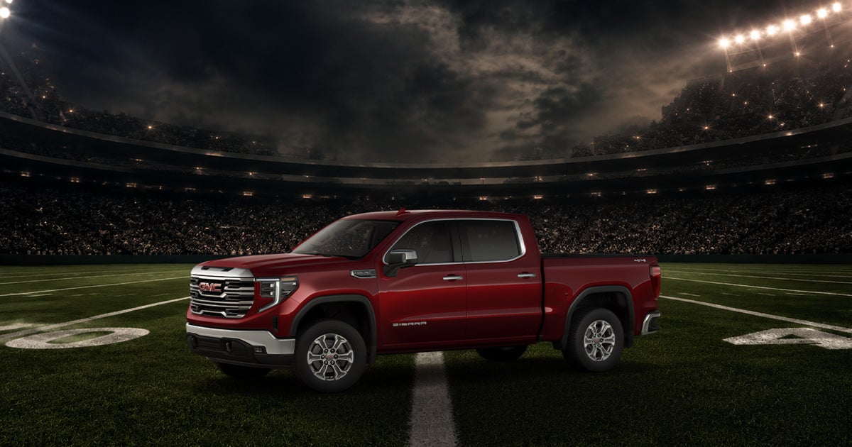 A red GMC Sierra 1500 on a football field